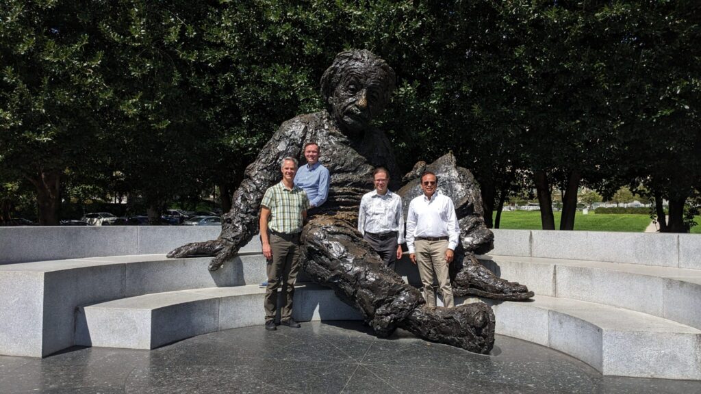 four people around a large Einstein statue