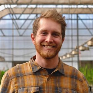 Larson in a greenhouse